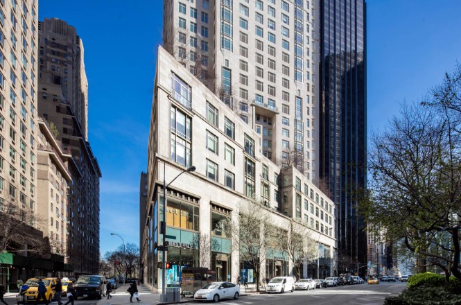Exterior of 1880 Broadway, the limestone retail base of 15 Central Park West in Manhattan, with the residential tower rising behind