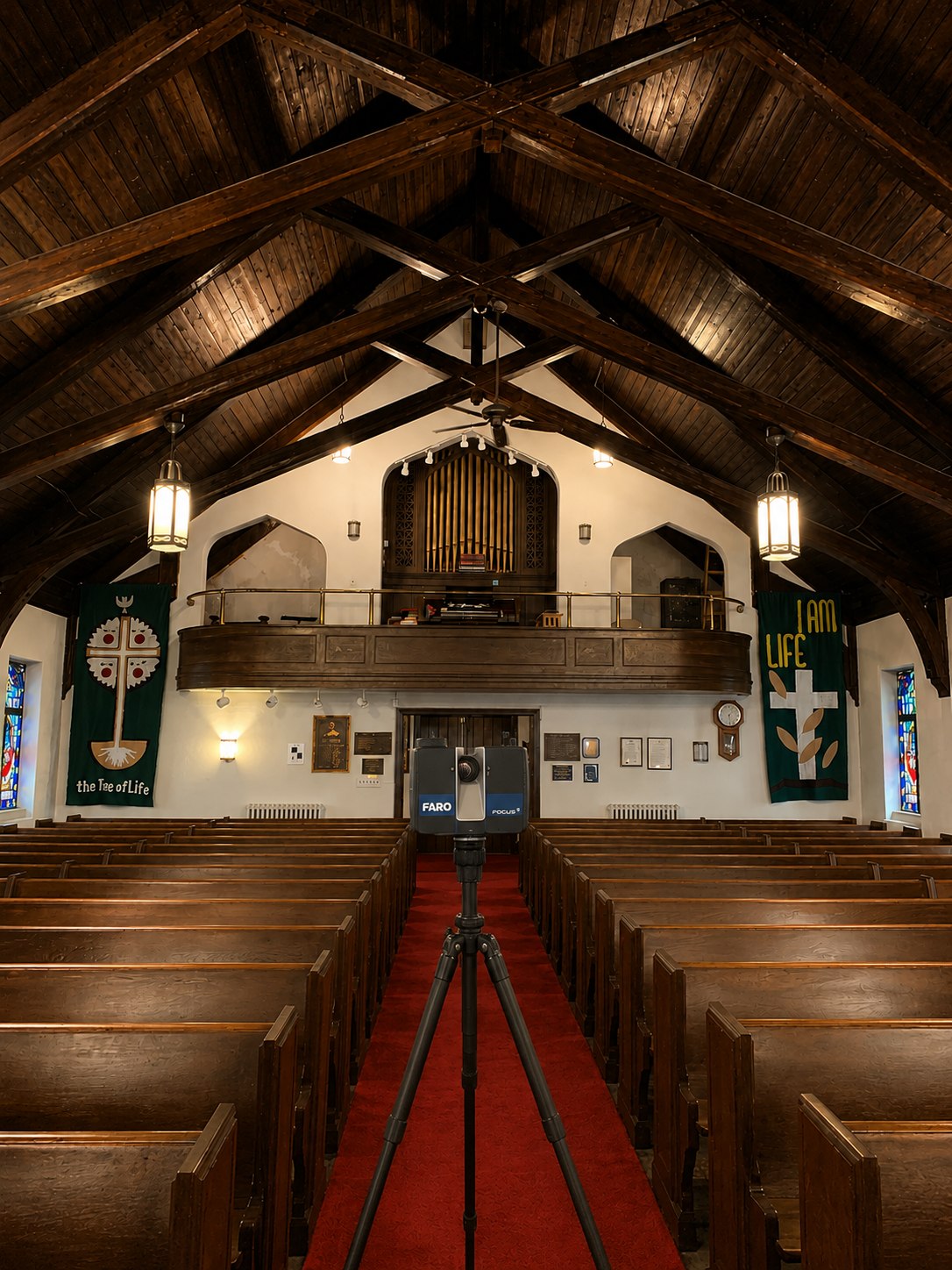 FARO laser scanner in the center aisle of the church sanctuary in Danbury, CT, under exposed timber roof trusses, facing the organ balcony and stained glass windows