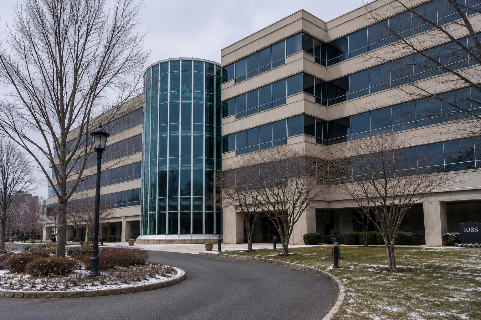 Exterior of the Kean University office building at 1085 Morris Avenue, Union NJ, with its curved glass atrium rotunda and stone-and-glass facade